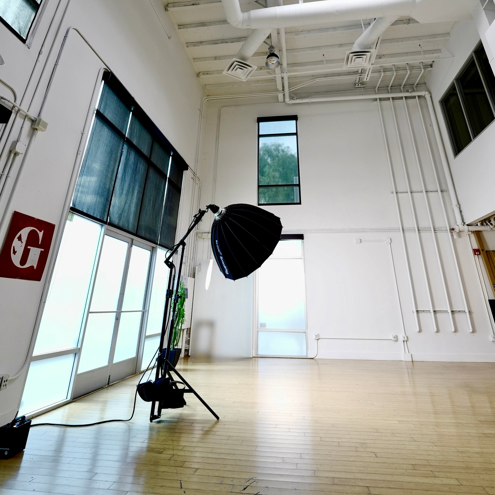 The Uptown Loft &mdash; the studio floor with strobe softbox under high ceilings and daylight.