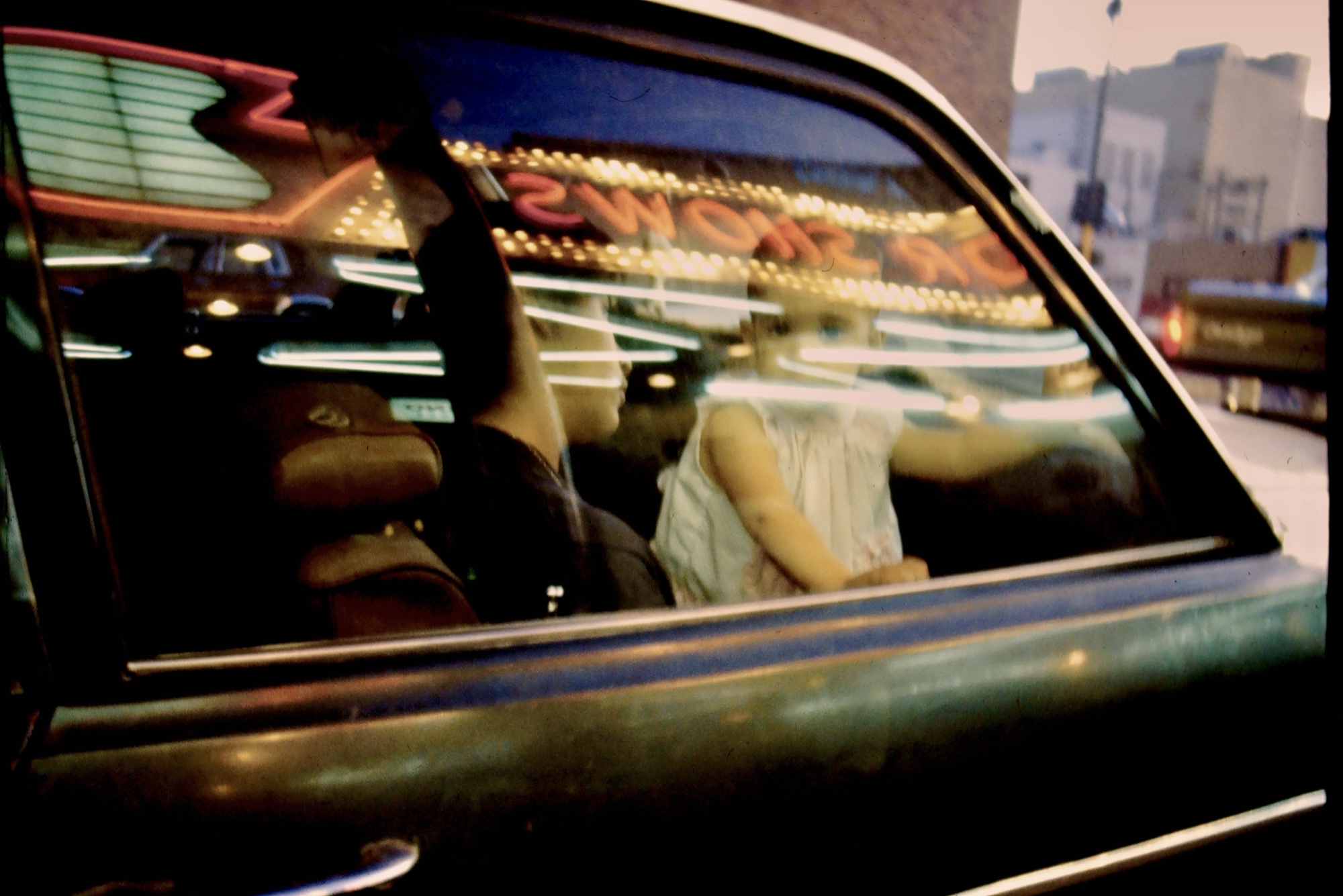 Editorial portrait by G. John Slagle &mdash; figures inside a car beneath the El Cortez marquee, downtown Las Vegas, available light, 35mm color film.