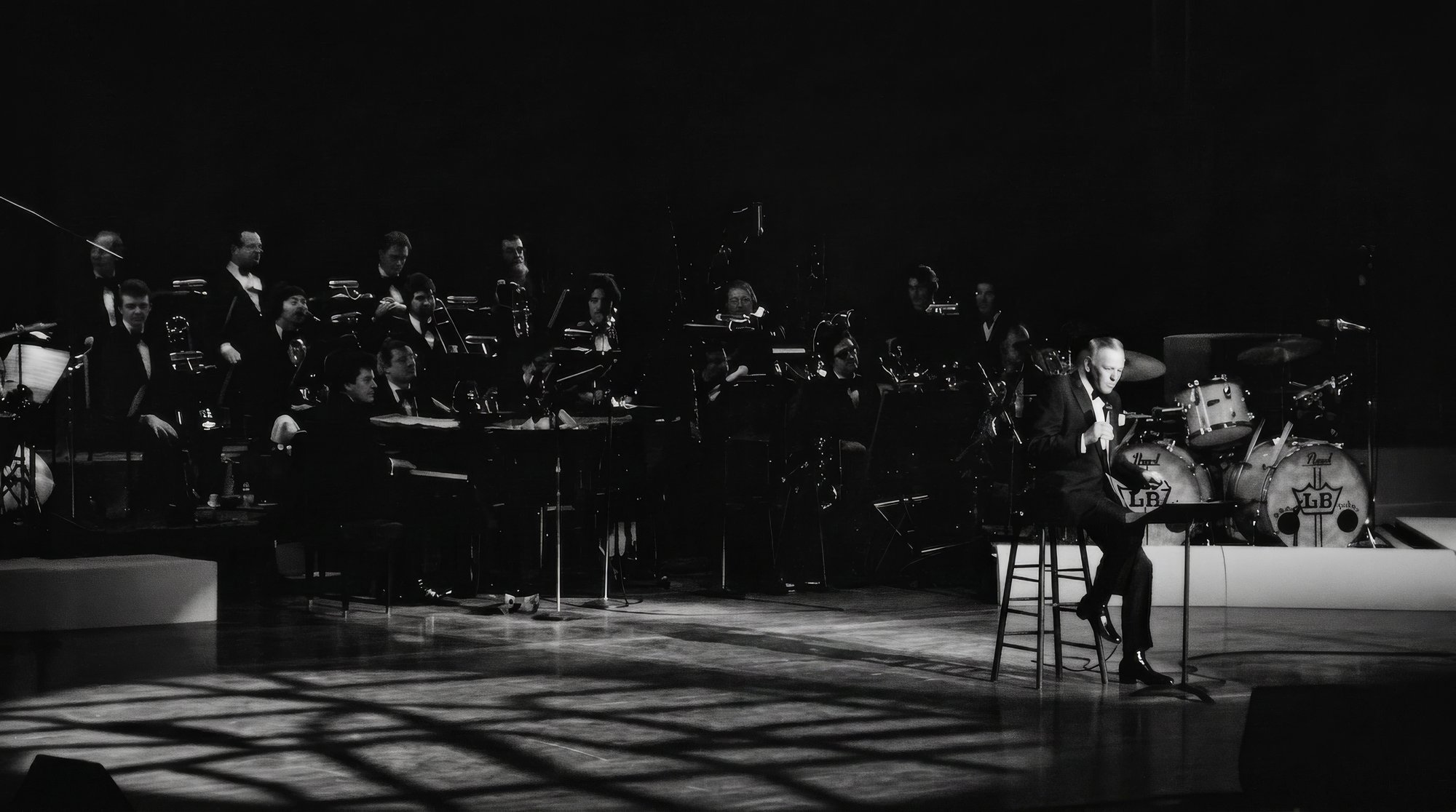 Frank Sinatra on stage with orchestra, spotlights, B&W, Las Vegas.