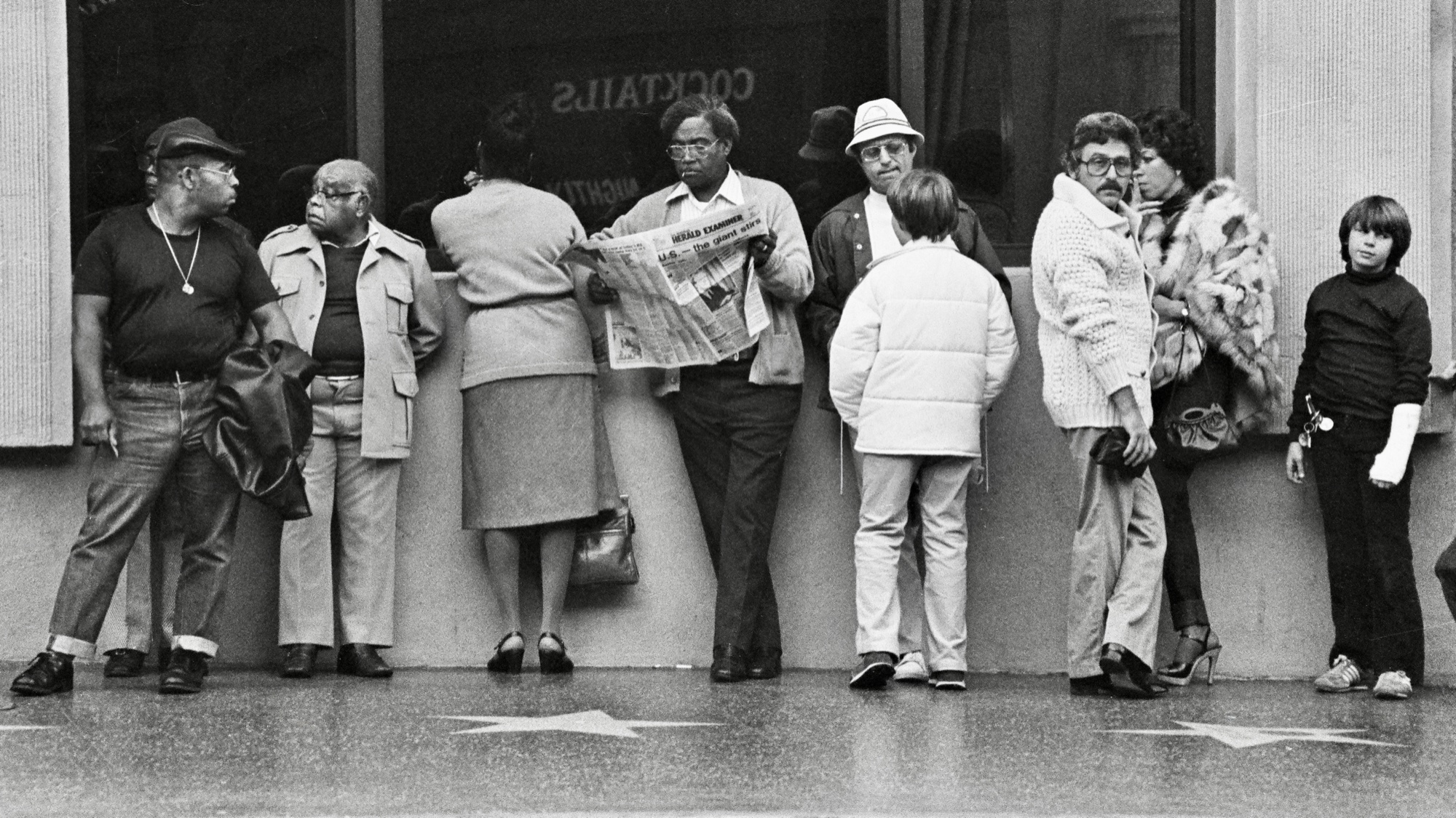 A line of bystanders along Hollywood Boulevard's Walk of Fame stars.